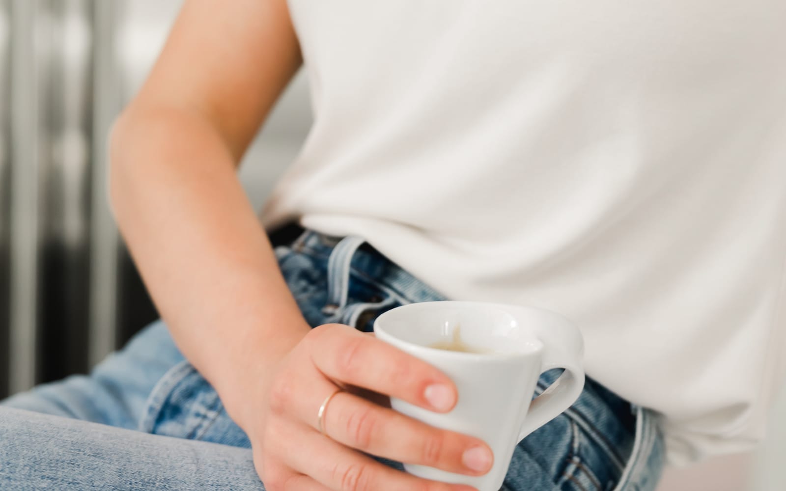 Frau umschließt eine warme Tasse, Symbolbild für die Behandlung einer Dünndarmfehlbesiedlung