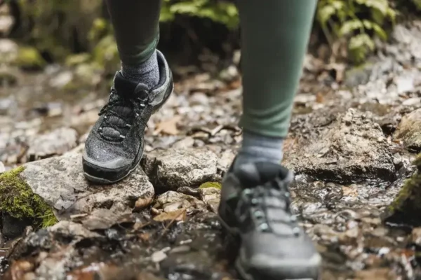 Wanderschuhe auf Steinen in einem Waldbach, Fastenwandern in der Natur mit Bauchgefühl